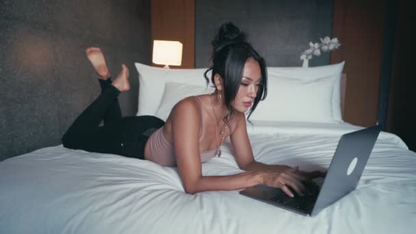 Mulher de negócios feliz com computador deitado no hotel na cama — Vídeo de Stock