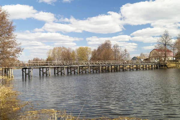 Wooden bridge through river at spring length of time — Stock Photo, Image