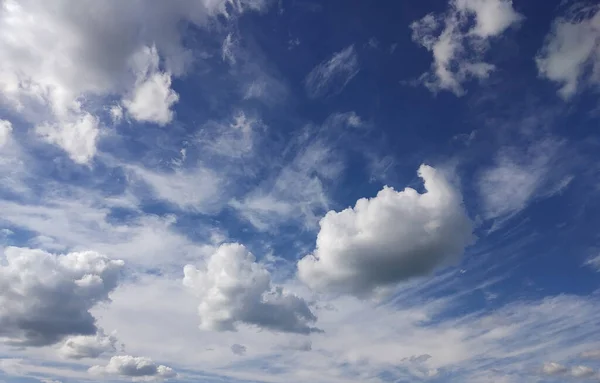 Mavi gökyüzü ve beyaz bulutlu arka plan. İlkbahar uzunluğunda göksel manzara