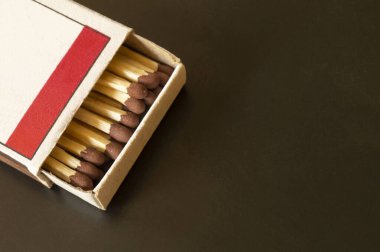 Siyah arka planda kibrit kutusunu açıyorum. Kağıt tahtadaki karton kutu. Kükürtlü tahta çubuklar.