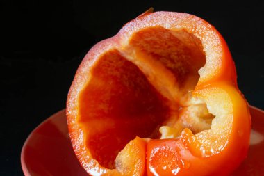 Siyah arka planda kırmızı biber tabağı. Beslenmenin yakın plan ürünleri