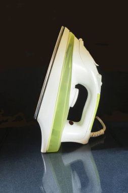 Elektrikli flatiron cam masaya dayanıyor. Siyah arkaplan üzerine inşa etme aracı