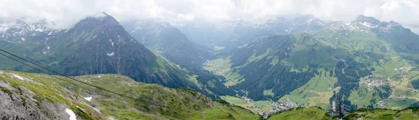 Ruefikopf 的全景视图 奥地利的莱赫 在莱赫山谷的山脉和绿色草地 周围的阿尔卑斯山笼罩在云层中 — 图库照片