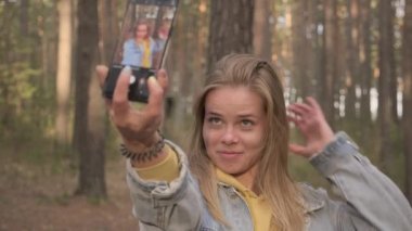 Genç kız selfie telefon güneşli ormandaki yapım