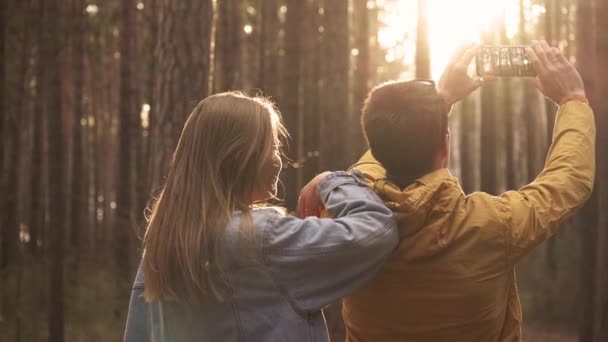 Genç adam ve kadın fotoğraf telefon ormandaki yaptırın — Stok video