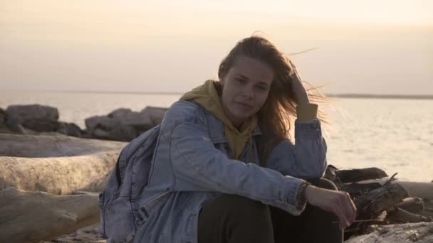 Trauriges Mädchen am Strand sitzt und denkt bei Sonnenuntergang — Stockvideo