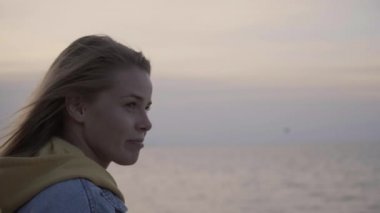 Deniz yukarıda gün batımında genç kadın portresi yüz