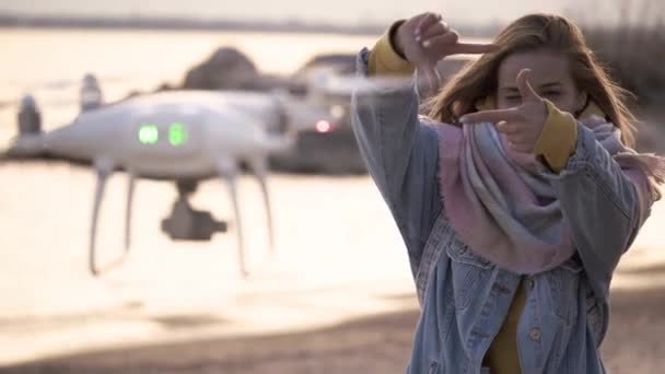 Смешная девушка снимает видео на пляже с помощью дрона — стоковое видео