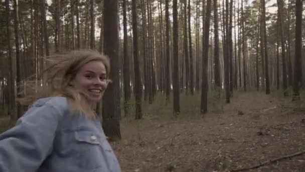Счастливая девушка, бегущая по лесу, держит друга за руку — стоковое видео