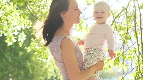 Lächelndes Kind lacht mit Mama über grüne Hinterhof-Zeitlupe — Stockvideo