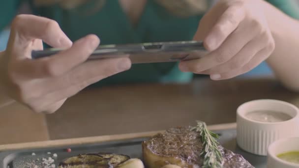 Handen van de vrouw maken een voedsel foto biefstuk met behulp van de telefoon — Stockvideo