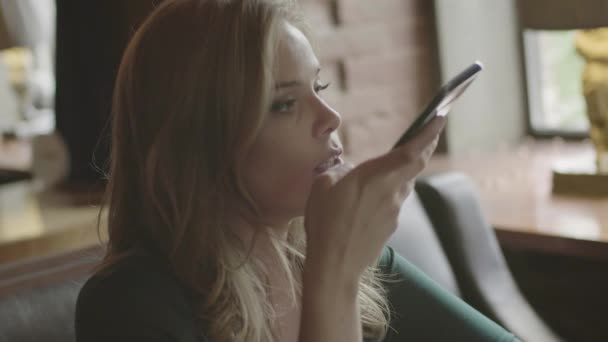 Vrouw verzenden audio bericht via telefoon zitten in café — Stockvideo