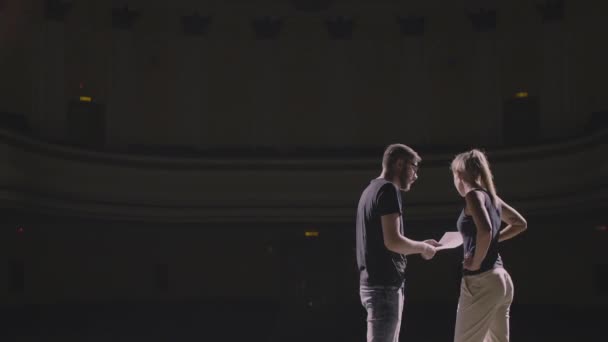 Мужчина и девушка читают сценарий на репетиции в театре — стоковое видео