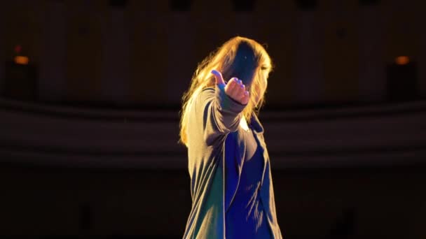 Jong meisje dansen op het podium onder de blauwe Binnendozen — Stockvideo