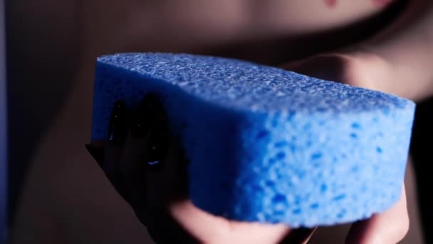 Woman holding in hand new shower sponge close up — Stockvideo