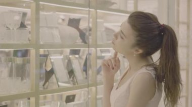 Kadın seçin alışveriş merkezi dükkan pencerede mal bakmak