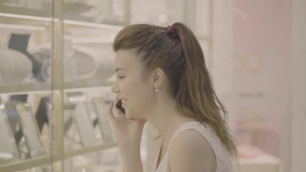 Kadın telefon konuşmak ve vitrin alışveriş merkezi olarak bakmak — Stok video