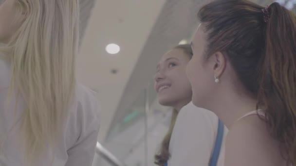 Flickvänner skratta på rulltrappa i köpcentrum — Stockvideo