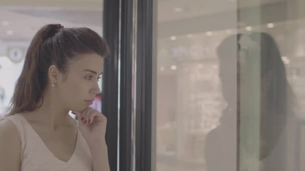 Schöne erwachsene Mädchen auf der Suche nach Schaufenster des Geschäfts — Stockvideo