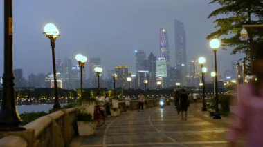 Akşam şehirde dolgu üzerinde yürüyen insanlar