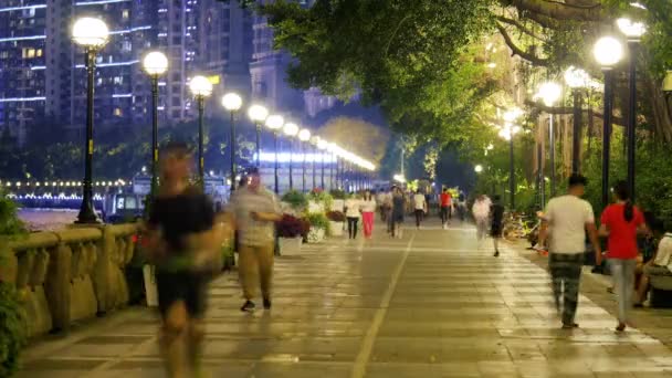 People walking on the embankment in evening city — Stock Video