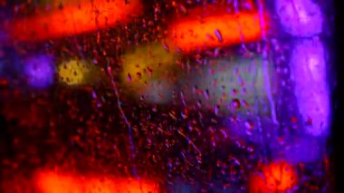 Yağmurlu bir şehirde gece hareket eden arabanın bulanık görüntüsü