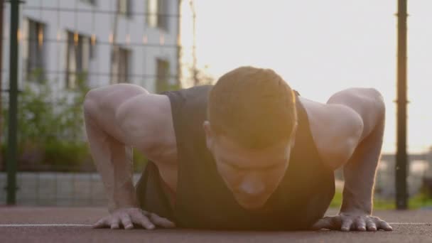 Muži Trénink dělá kliky na městské hřiště pro košíkovou — Stock video