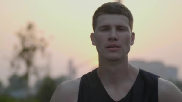 Basketbalspeler op zoek naar camera en glimlachen — Stockvideo