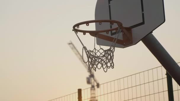 Basketbalový koš zblízka při západu slunce a vstřelil míček — Stock video