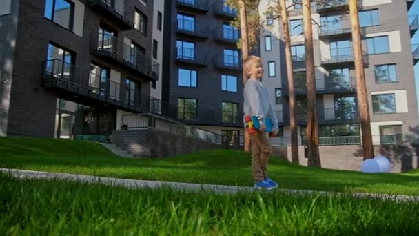 Garçon avec planche à roulettes debout à l'aire de jeux urbaine — Video