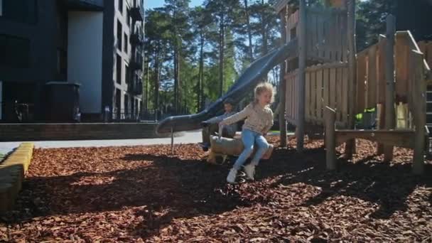 Niños felices jugando en el patio de recreo cerca de casa — Vídeos de Stock