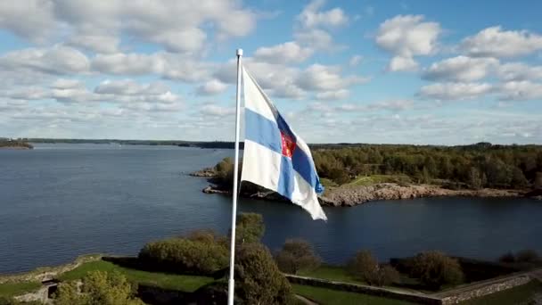 日本の記号フィンランドのフラッグスタッフは曇りのスカイラインの背景に手を振る — ストック動画