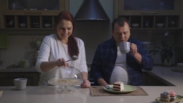 Cocinero confitero femenino y masculino cocinero biológico saludable cupcakes degustación de una rebanada — Vídeo de stock