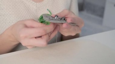 Beyaz alanda çalışan Lady Terzi giysiler için bir mücevher öğesi bağlayacak