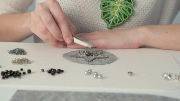 Jeune designer dans l'espace de travail fera un bel article de bijoux pour les vêtements — Video