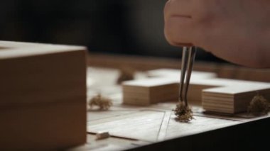 Ustalar, ahşap düzen üzerinde cımbız ile dekoratif çalılar düzenler