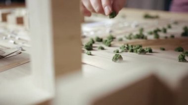 Ustalar bir ahşap düzen üzerinde parmaklar ile dekoratif çalılar düzenler