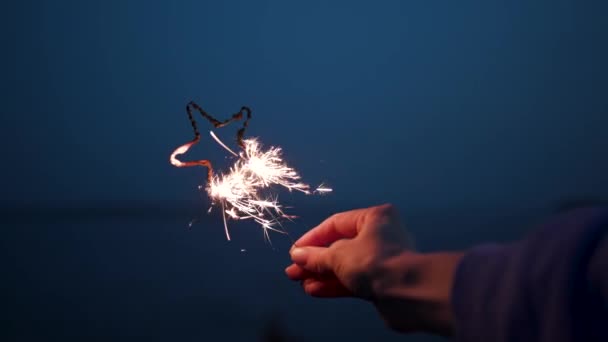 Feestjes Alleen Jonge Hand zwaaien Golden Shine Sparklers en opwinding 4k — Stockvideo