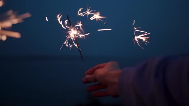 Weihnachtsbeleuchtung spritzt in die Hände Menschen feiern Emotionen Hintergrund — Stockvideo