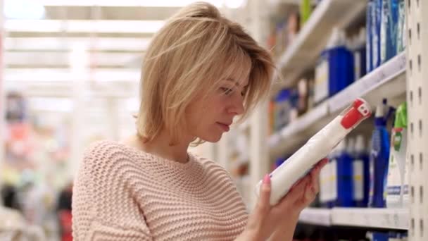 Kobieta po trzydziestce wybiera butelkę detergentu w sklepie z artykułami gospodarstwa domowego Close-up 4k — Wideo stockowe