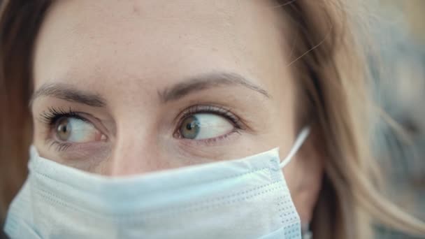 Retrato de cerca Mujer adulta con máscara protectora de la cara médica y mirando — Vídeo de stock