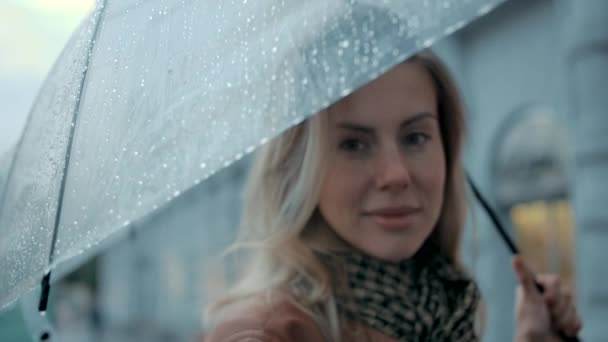 Primer plano Retrato Una sonrisa femenina bajo paraguas ante la lluvia que cae en la ciudad 4k — Vídeos de Stock