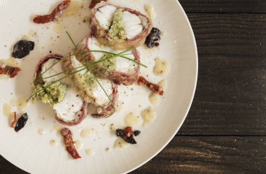 pastırma siyah arka plan üzerine sarılı morina balığı