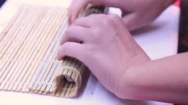 Portre manzara haddeleme suşi hazırlama işleminin. Bambu hasır Nori ve beyaz pirinç. 
