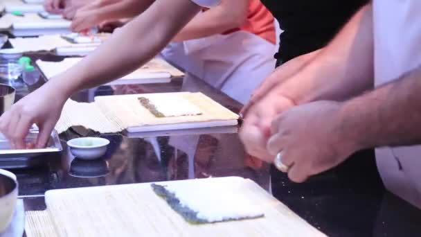 Closeup véve előkészítése során a gördülő sushi. Bambusz mat a nori és a fehér rizs. 