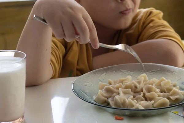 Boy kid eating pasta at home kitchen with yogurt — Stock Photo, Image
