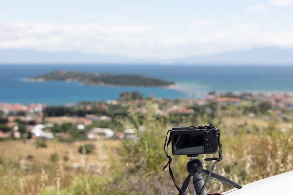 Digital camera on camera tripod taking a photo of panoramic landscape