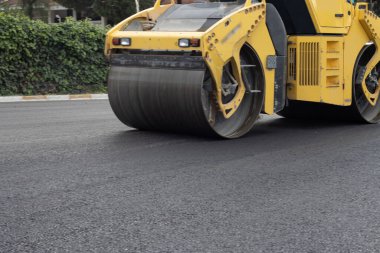 Yeni asfalt yol. Yol asfaltı çalışıyor. İnşaat çalışmaları.
