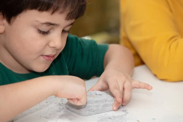 Image of an educational game to find fossils for a small archaeologist, with childrens hands digging — Stock Photo, Image