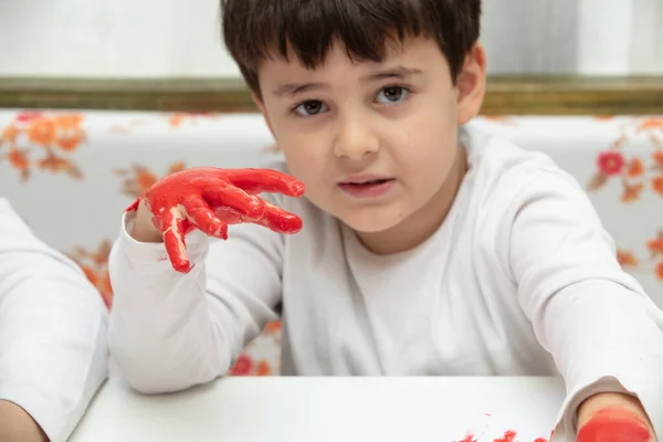 Großaufnahme kleiner Junge beim Malen mit bunten Händen. Kunst, Kreativität und Malkonzept — Stockfoto
